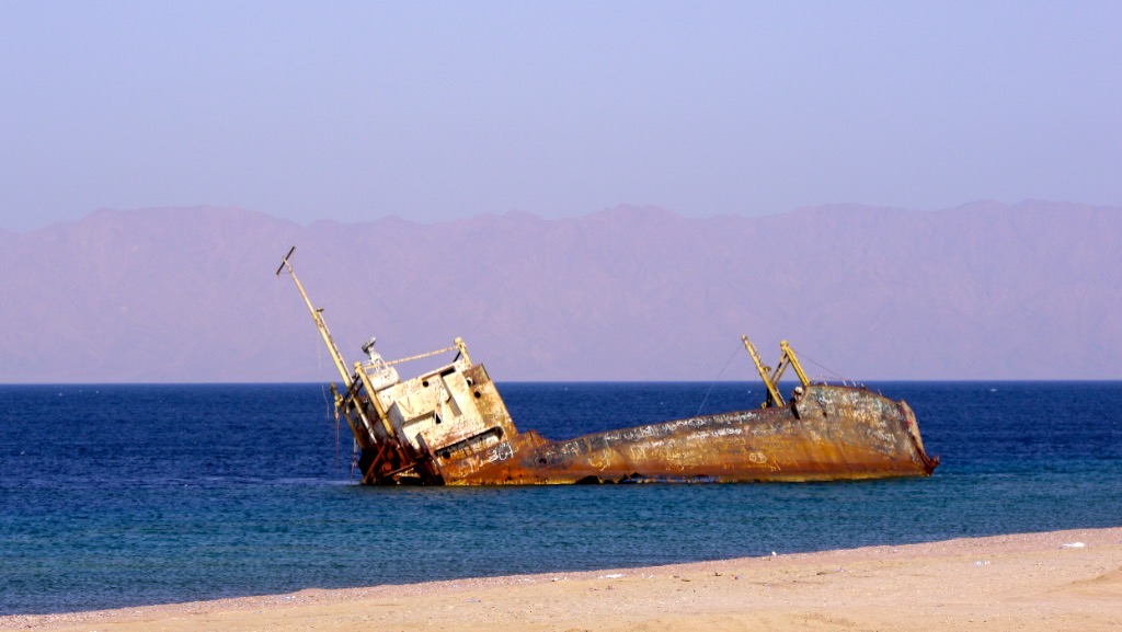 The wreck in full daylight, rusted hull against turquoise water